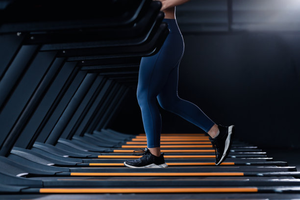 亚洲美丽的运动女性穿着运动服与锻炼头带在跑步机健身房锻炼是健身生活方式中的运动健康的身体建设。图片下载