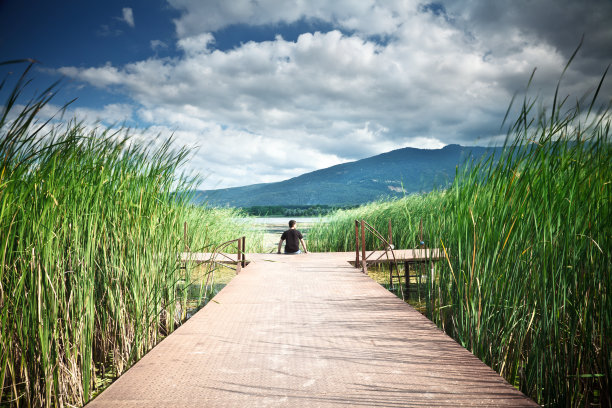 坐在湖边码头上的年轻人图片下载