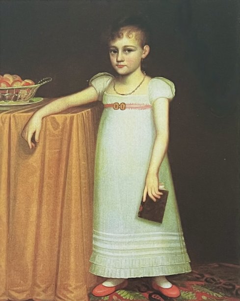 女孩站在桌子旁，左手拿着一本书，右手倚在桌子上图片下载