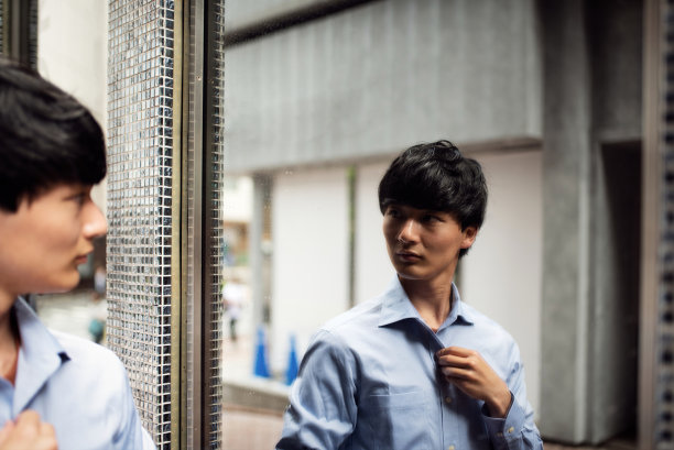 一个年轻人在街上对着镜子看自己图片下载