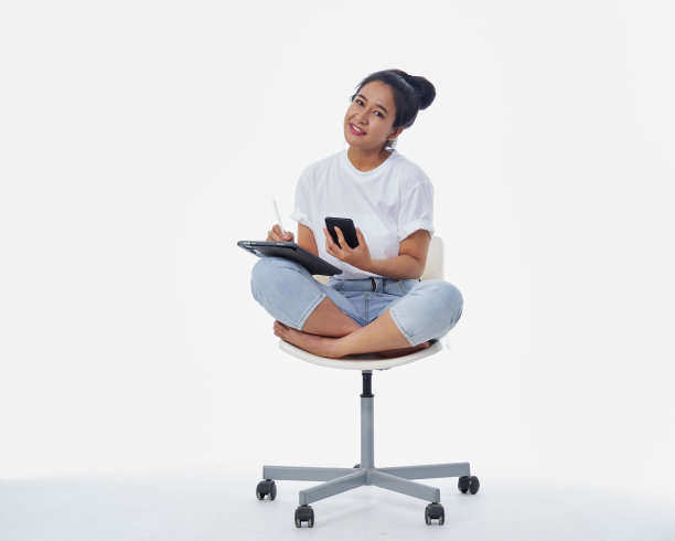 快乐的年轻女子一边用平板电脑一边打电话图片下载