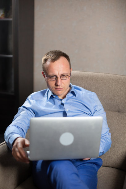 戴眼镜的男员工若有所思地看着笔记本电脑屏幕图片下载