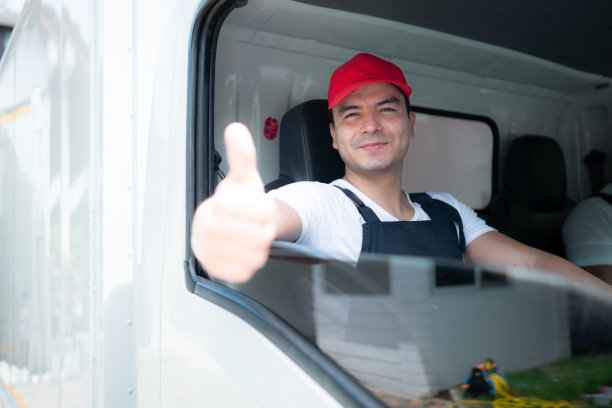 微笑的快递员坐在车门后竖起大拇指图片下载