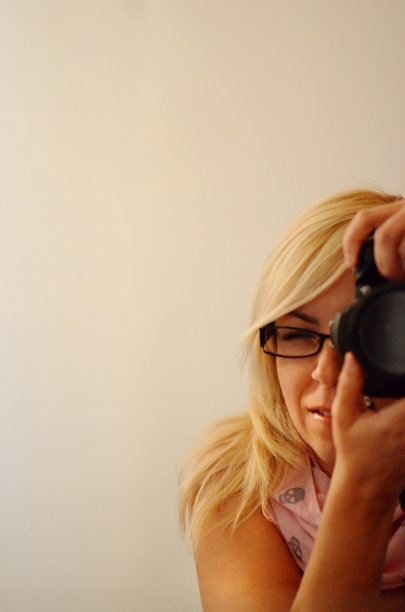 一位女摄影师拿着相机对着镜子给自己拍照图片下载