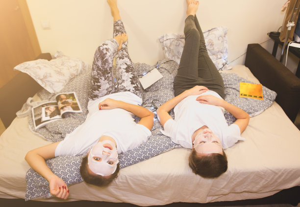 女孩们用面膜贴在脸上。在家做美容手术。母鸡派对。女人玩得开心。图片下载