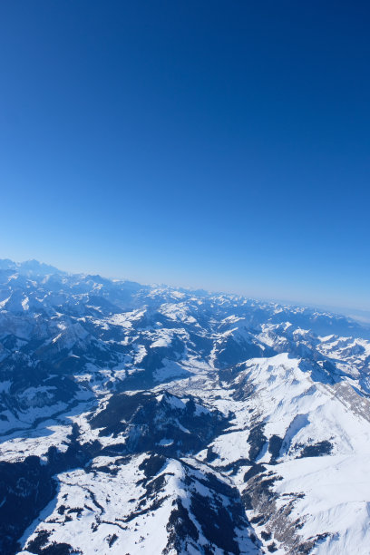 热气球乘坐在瑞士阿尔卑斯山与清澈的蓝天和冬季雪山，鸟瞰摄影图片下载