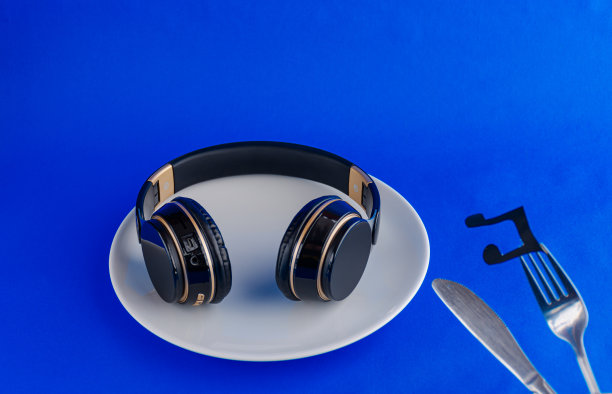 黑色耳机在皇家蓝色的背景。无线耳机。照片与文字空间。音乐概念，用音乐概念喂自己。图片下载