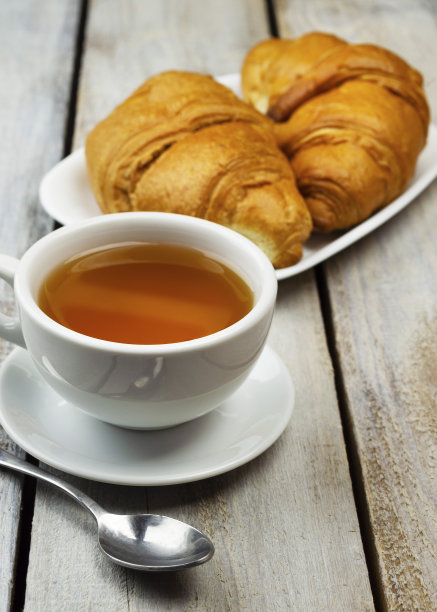 黑色背景上的牛角面包特写。新鲜美味的法式糕点，烘焙理念，特写画面。茶。图片下载