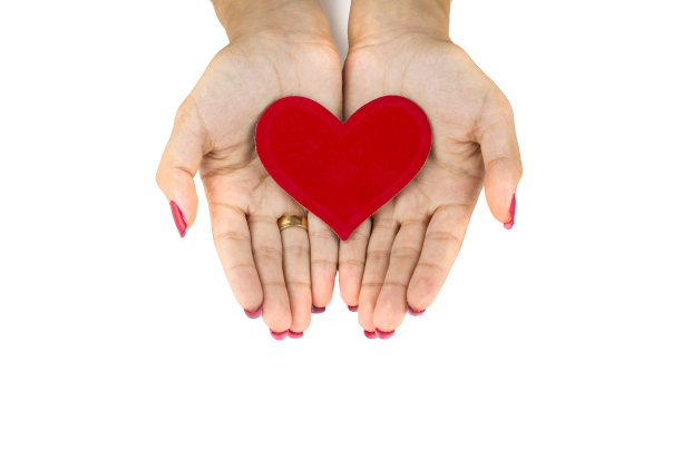 女人双手捧着红心做成的塑像图片下载