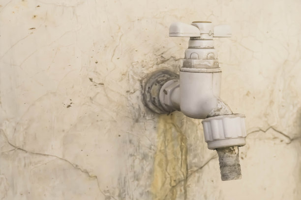 白色的水龙头在粗糙的灰色水泥混凝土墙上图片下载