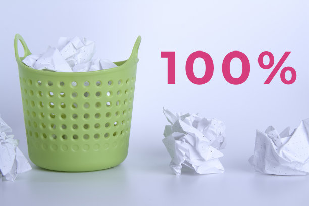 绿色的垃圾桶。完整的篮子里。放在篮子里的皱巴巴的纸。桌子上散落着堆积如山的垃圾。100%了。图片下载