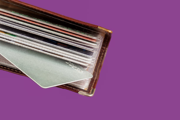 紫色背景上装满名片的皮革卡包图片下载