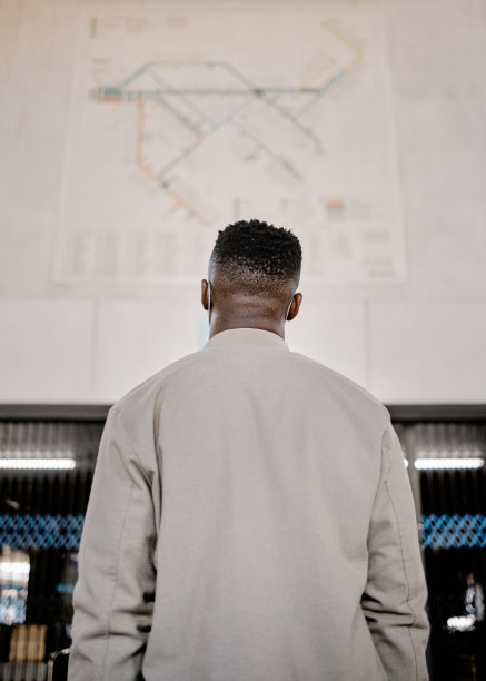 一个黑人在车站旅行时看地图。看地图寻找指引和方向图片下载