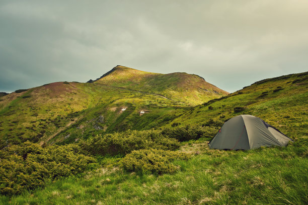 夏天的景色，小舒适的现代旅游帐篷在美丽的蓝天下，在多雾的山上覆盖着森林的背景。图片下载