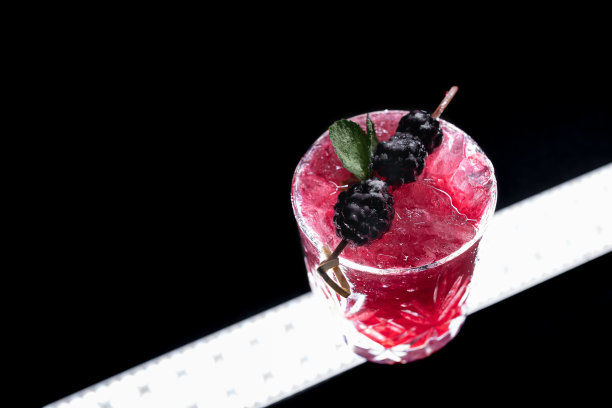 特写的酒精蓝莓特别鸡尾酒与黑莓在葡萄酒杯图片下载