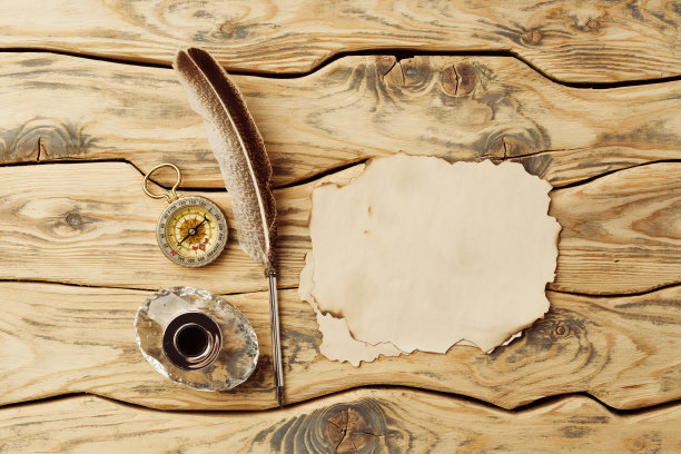 旧纸在棕色的木头背景与羽毛图片下载