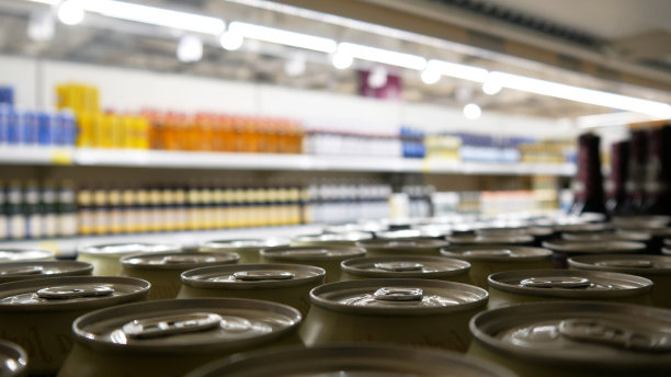 商店货架上许多白色啤酒罐的特写图片下载