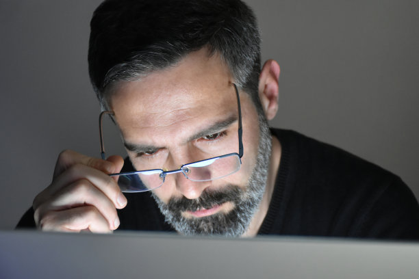 戴眼镜的男子在电脑前工作图片下载