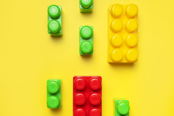彩色塑料孩子构造的黄色背景。彩色儿童建筑砖。平面俯视图拷贝空间。塑料积木背景。开发玩具、游戏图片下载