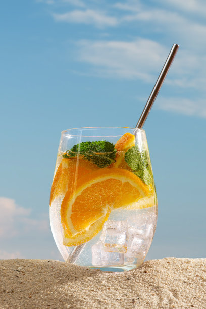 莫吉托鸡尾酒与柑橘酸橙，柠檬和橘子在海滩上图片下载
