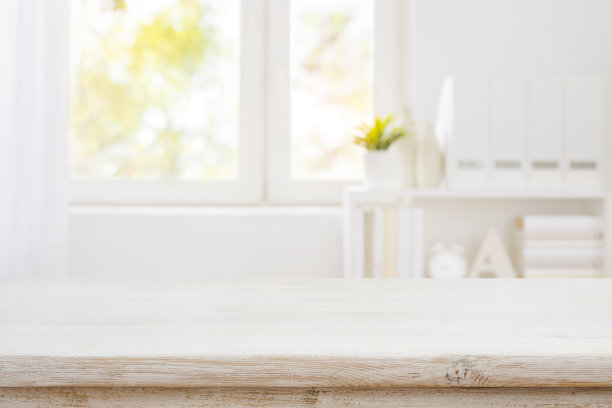 木桌前面是模糊的书架和窗户背景图片下载