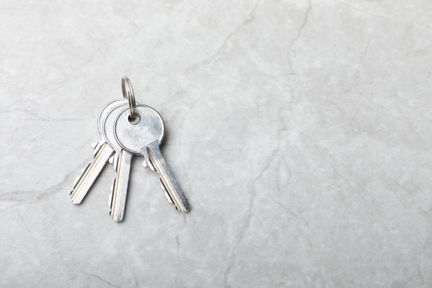 房子的钥匙。灰色大理石背景的构图。设计元素。房地产和保险概念。副本的空间。图片下载