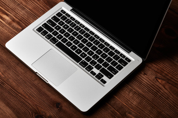 棕色木桌上的笔记本电脑键盘。图片下载