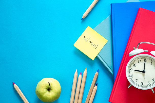 蓝色背景上的彩色教育用品的平面构图。图片下载