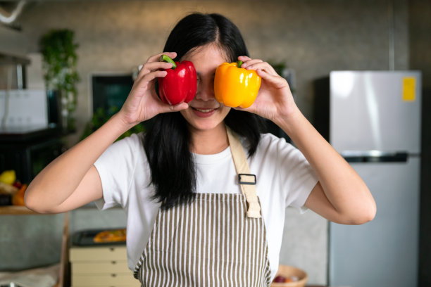 微笑快乐的亚洲女厨师带着新鲜的营养蔬菜，在家里的厨房做早餐和晚餐，用菜单食谱健康的生活方式图片下载