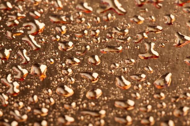 金色背景上的彩色水滴。抽象液体喷雾剂图片下载