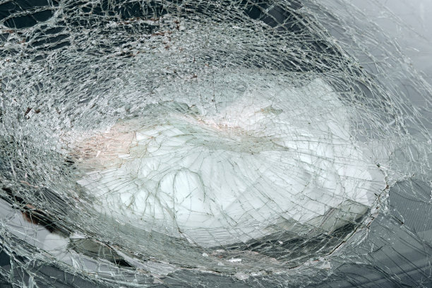 一辆汽车破碎的玻璃和打开的驾驶员安全气囊的特写。图片下载