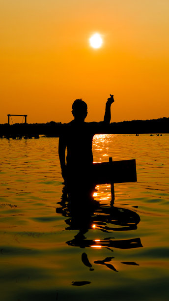 在海滩上欣赏日落的剪影照片图片下载