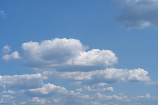 白色蓬松的云朵在黑色的背景和蓝色的天空下显得格外显眼图片下载