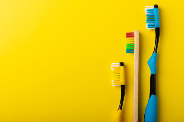 口腔护理。黄蓝色背景上的牙刷。浴室化妆产品的概念。平铺，俯视图，复制空间。一套口腔护理产品。口腔卫生图片下载