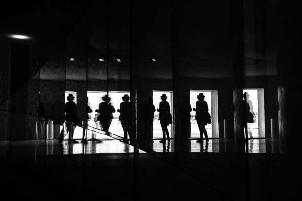 帽人阴影，反映在一个现代建筑的窗户上，波尔图，葡萄牙。图片下载