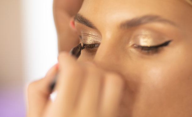 化妆师在美容院的女孩眼皮上画箭头，特写图片下载