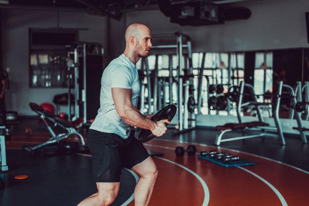 健身房里的帅哥头上顶着一个重物，照片图片下载