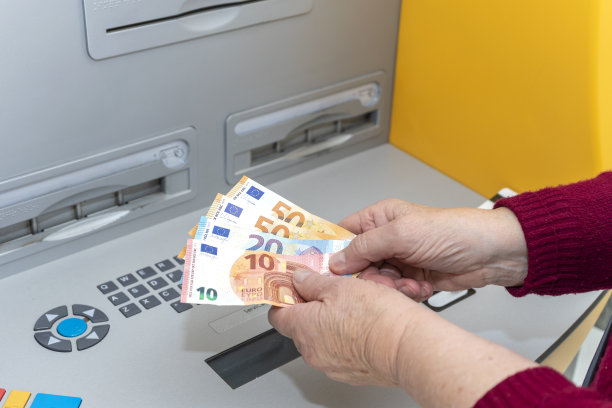 退休的老年妇女正在从自动取款机上取钱。老年人之间的数字鸿沟。图片下载