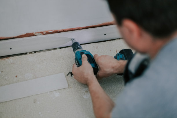 一个年轻人用螺丝刀拧下一个螺丝。图片下载