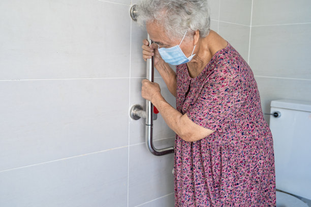 亚洲老年或老年老年妇女妇女病人使用卫生间卫生间处理安全护理病房，健康医疗观念强。图片下载