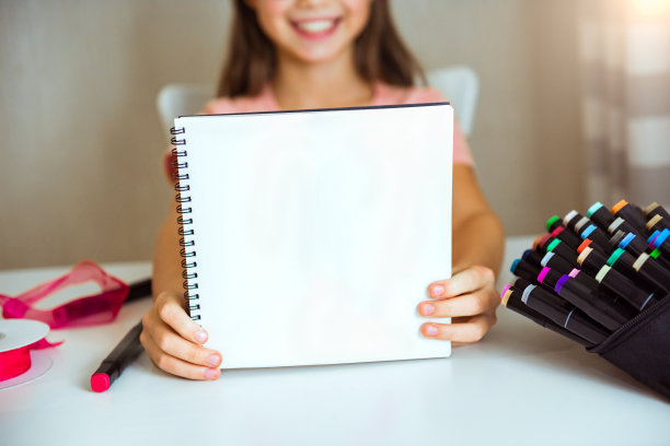 快乐的小女孩展示了空白的相册和干净的白纸。刻字的空间，模型图片下载