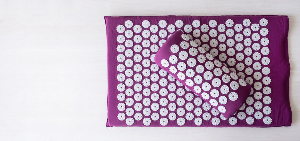 白色背景的按摩垫。替代医学的概念。针灸按摩垫配枕头。图片下载