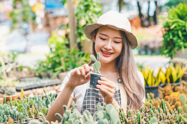 年轻女性的爱好是照顾植物，浇水，铲花。在工作休息的时候在花园里图片下载