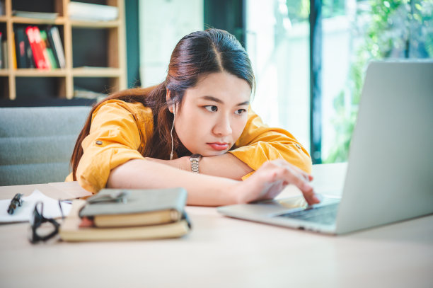 又累又无聊的女商人在咖啡馆里用笔记本电脑上网图片下载