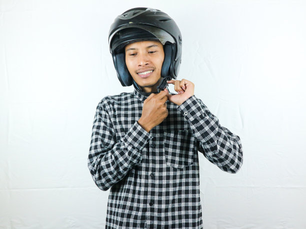 亚洲男子手持摩托车头盔，表情激动。安全骑。图片下载
