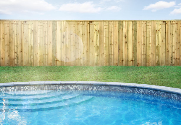 游泳池在后院与绿色的草地和木栅栏图片下载