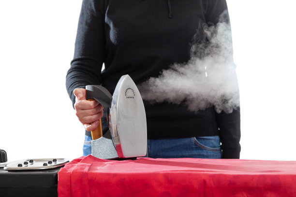 白色背景上女主人手中的蒸汽熨斗图片下载