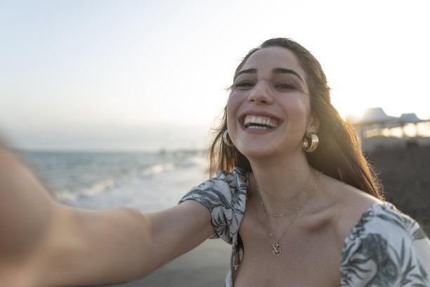 在沙滩上自拍的女人。图片下载