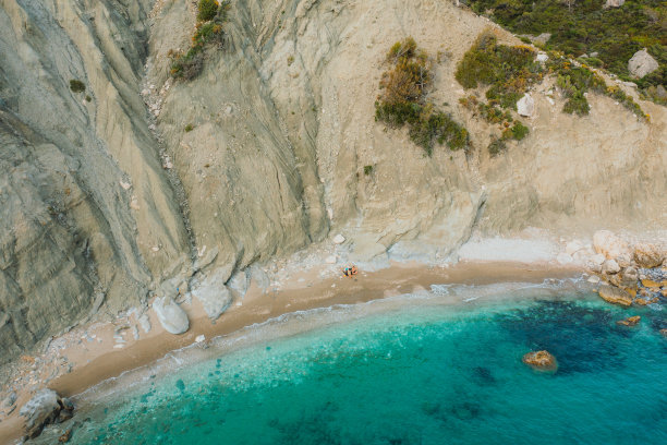风景鸟瞰图的女人和男人在遥远的海滩上沐浴在水晶蓝色的大海在土耳其图片下载