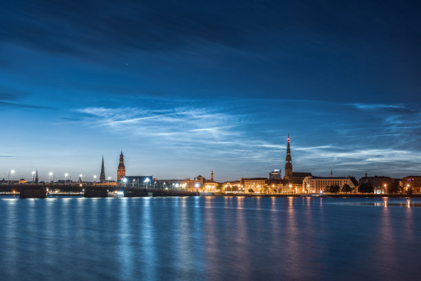 七月的夜晚，道加瓦河上的夜光云和老里加镇和石桥的景色。长曝光摄影。图片下载